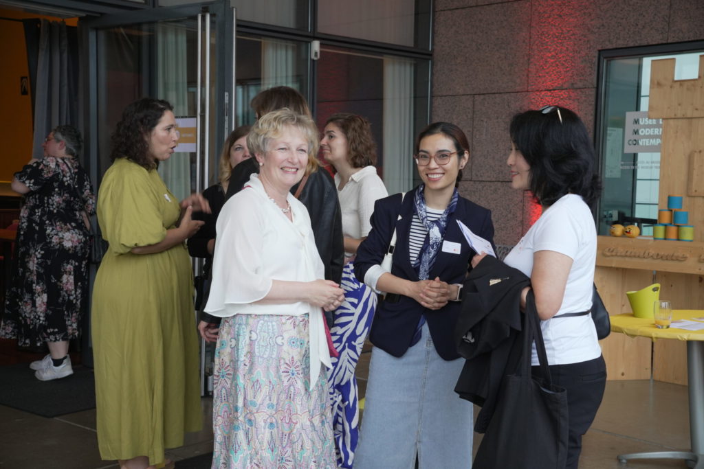 Director of the CAWEB Master’s program, Renate de la Paix, talks with students, alumni, and instructors during the program's 20th-anniversary celebration.