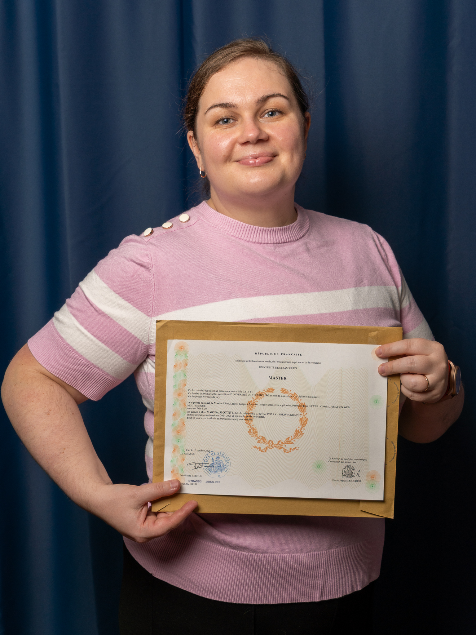 Maryna Mottet holding her Masters Degree Certificate